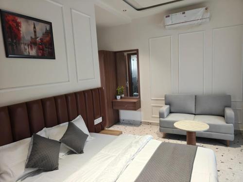 a bedroom with a bed and a couch and a chair at Hotel Natraj Sirsa in Sirsa