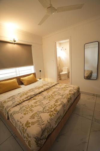 a bedroom with a large bed and a toilet at HomeSlice Sarjapur - Balcony Rooms in Bangalore
