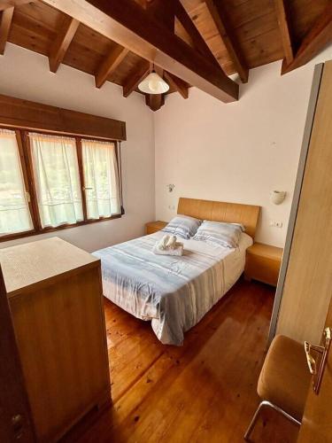 a bedroom with a bed in a room with wooden floors at Chalet con jardín junto a playas in Colunga