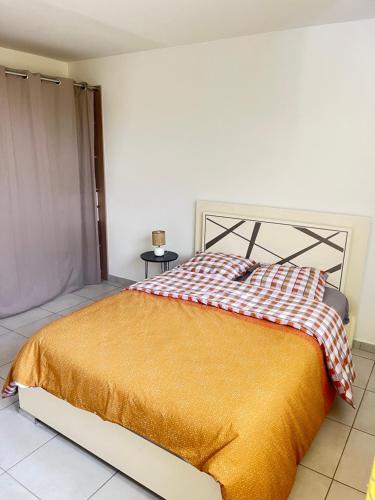 a bedroom with a bed with a red and white blanket at Cozy spa sun set in Trois Bassins