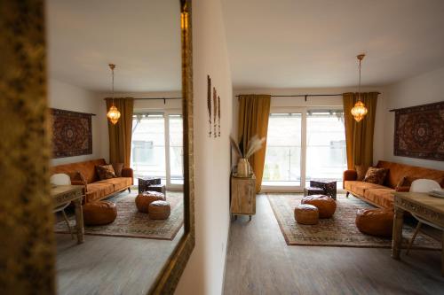 a living room with a couch and a mirror at Signature Suites Sauerland in Winterberg