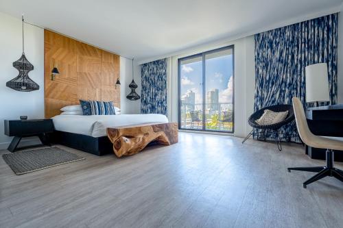 a hotel room with a bed and a desk and a window at Angler's Hotel - Miami Beach in Miami Beach