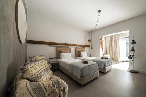 a bedroom with two beds and a couch at Evia Silence in Boufalo