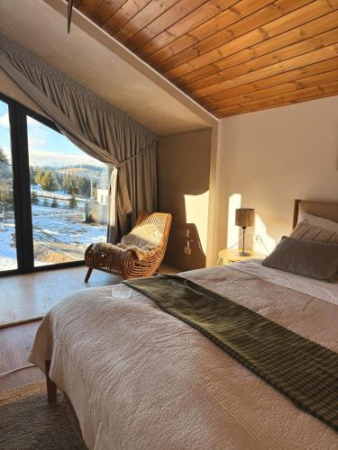 a bedroom with a bed and a large window at Altitude Escape Retreat in Fundata