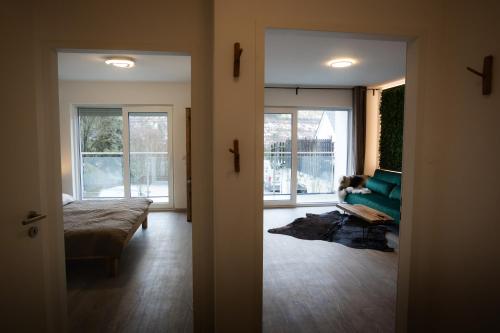 a living room with a green couch and a window at Signature Suites Sauerland in Winterberg