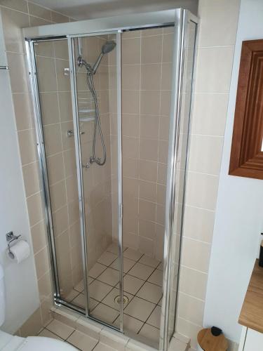 a shower with a glass door in a bathroom at Beach and Breeze in Mooloolaba