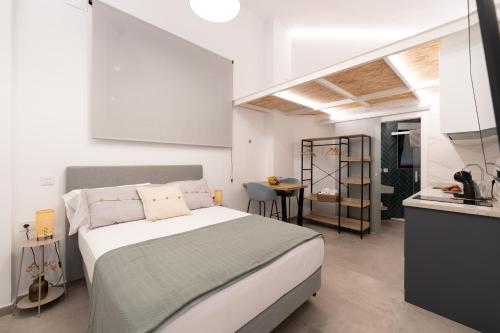 a white bedroom with a bed and a kitchen at Baélia Experience Hotel boutique in Alicante