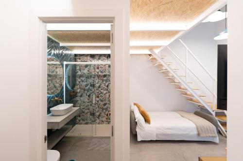 a room with a bed and a staircase and a bathroom at Baélia Experience Hotel boutique in Alicante