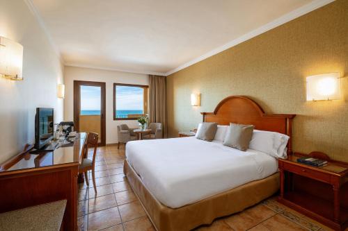 a hotel room with a large bed and a television at Hotel IPV Palace & Spa - Adults Recommended in Fuengirola