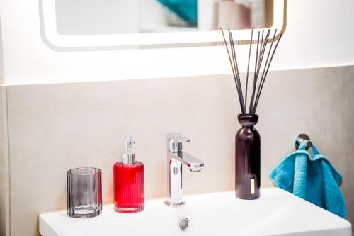 a bathroom sink with a vase and a faucet at RheinView Residence - Apartment in Mainz
