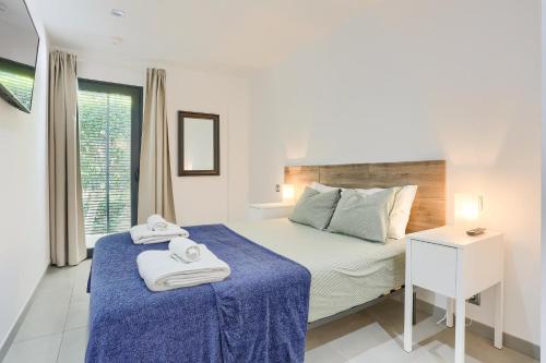 a bedroom with a bed with a blue blanket at La Perla 3 in El Port