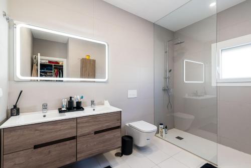 a bathroom with a sink and a toilet and a mirror at Prime House Lisbon in Famões