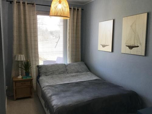 a bedroom with a bed and a window and a lamp at Apartament Lubię błękit in Jantar