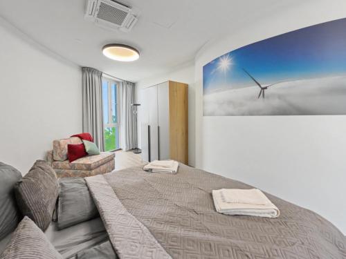 a bedroom with a bed and a picture of a wind turbine at NORA Turmhaus am Bergheider See in Buschmühle