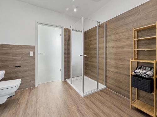 a bathroom with a glass shower and a toilet at NORA Turmhaus am Bergheider See in Buschmühle