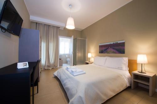 um quarto com uma grande cama branca e uma televisão de ecrã plano em Tiffany Rooms em Milão