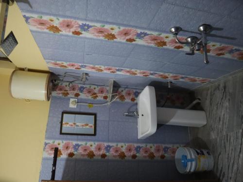 a bathroom with a toilet paper dispenser on the wall at Chaukhamba view stay in Gupta Kāshi