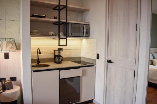 a small kitchen with a sink and a microwave at Hotel Ryo 74B Suites by Growing Group in Medellín