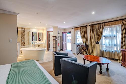 a living room with a bath tub and a bathroom at Lourie Lodge in Johannesburg