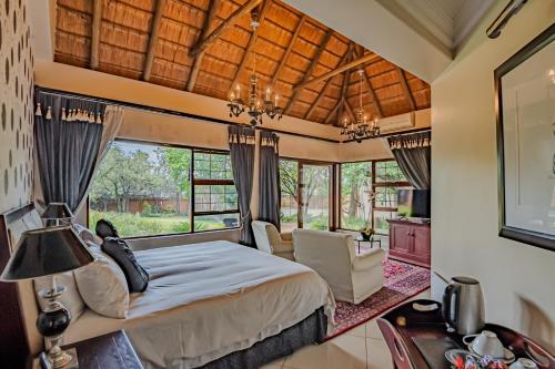 a bedroom with a bed and a large window at Lourie Lodge in Johannesburg