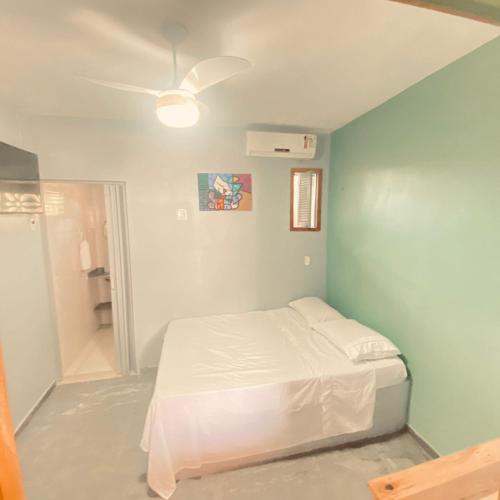 a bedroom with a bed and a blue wall at Porto Mirim House in Ceará-Mirim