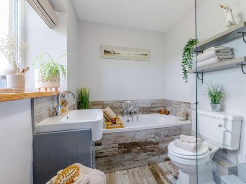 a bathroom with a tub and a toilet and a sink at 3 Bed in Matlock oc-86482 in Cuckney
