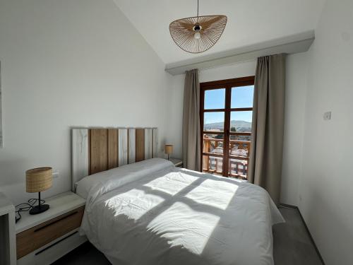 a white bedroom with a bed and a window at Hotel Apartamento 3 Lobitos in Villardeciervos