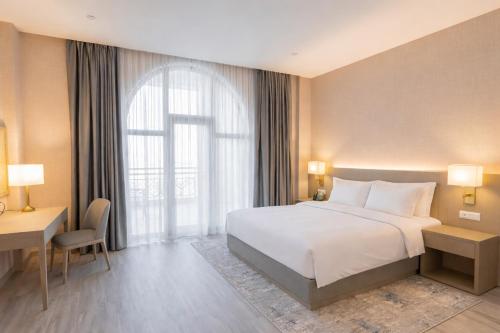 a hotel room with a bed and a window at Yevlakh City Hotel in Yevlax
