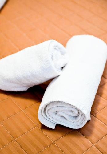 a white towel laying on the floor at Oleander Garden in Alexandroupoli