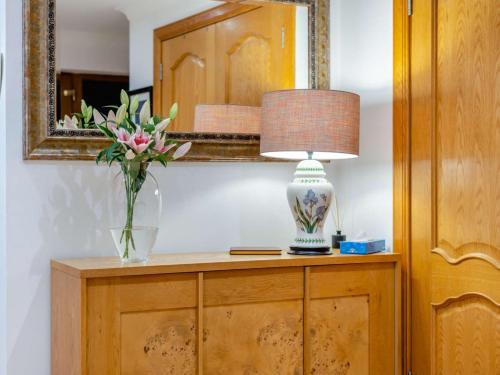 a vase of flowers and a lamp on a cabinet at 3 Bed in Bathgate oc-90491 in Fauldhouse