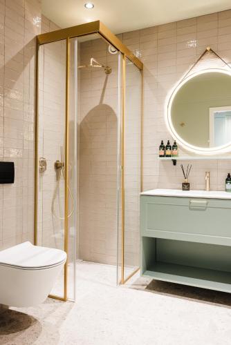 a bathroom with a shower and a toilet and a sink at Reykjavik Residence Apartment Hotel in Reykjavík