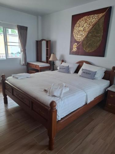 a bedroom with a large bed with white sheets at Cozy Country House with Pool in Ban Nong Nam Khem