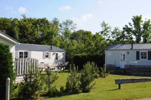 a campsite with a caravan and a house at Vakantiepark Dennenoord in Den Burg