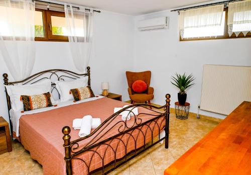 a bedroom with a bed and a chair at Oleander Garden in Alexandroupoli