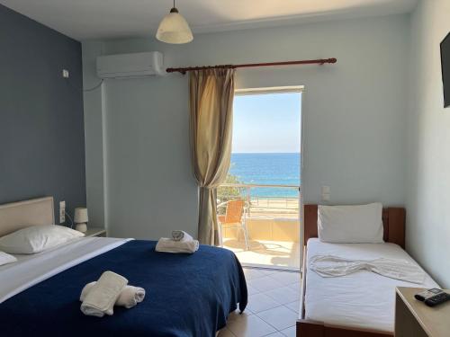 a bedroom with a bed and a view of the ocean at Hotel Prinos in Himare