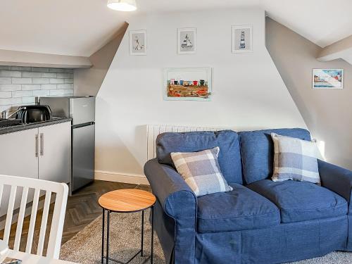 a blue couch in a living room with a kitchen at Lily - Uk49362 in Bridlington