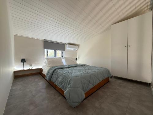 a bedroom with a large bed in a white room at Eretria Lofts in Eretria