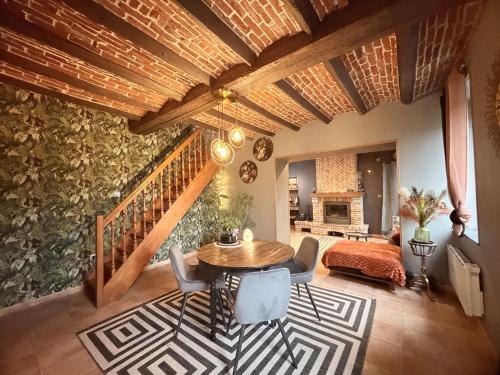 a living room with a wooden table and a staircase at Suite Home in Crespin