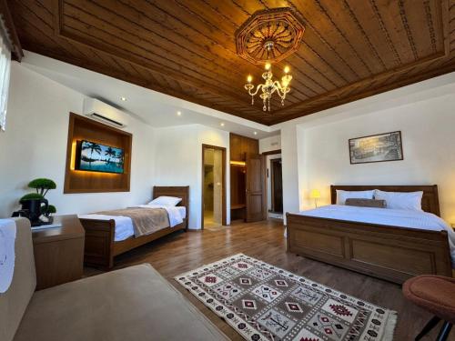 a bedroom with two beds and a chandelier at Hotel with Castle View in Gjirokastër