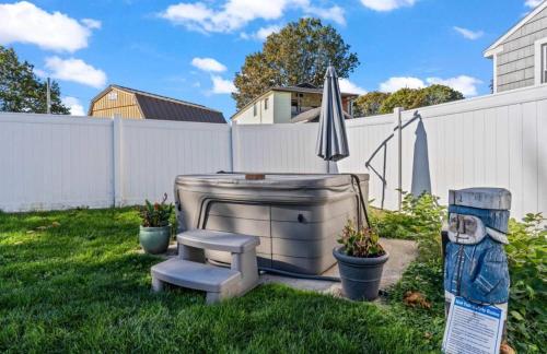 a hot tub sitting in a yard next to a fence at The Driftwood in Old Orchard Beach