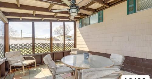 a patio with a table and chairs and a large window at The Driftwood in Old Orchard Beach
