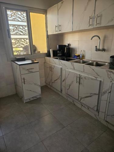 a kitchen with white cabinets and a sink at Mimi in Dakar