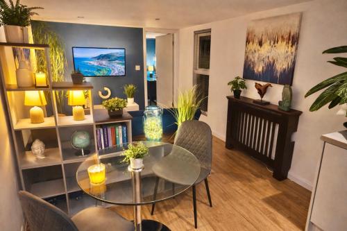 a living room with a glass table and chairs at A Hidden Gem With Private Hot Tub and Garden - Netflix - Fast Wifi - Free Parking in Bournemouth