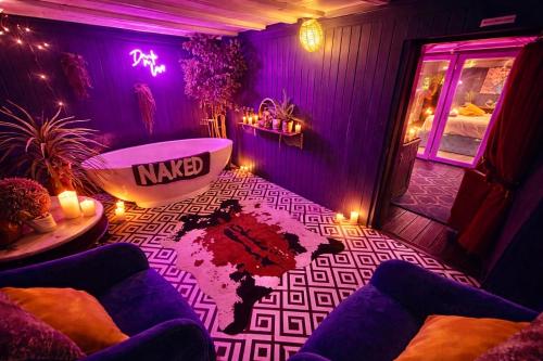 a purple room with a bath tub and a table at A Hidden Gem With Private Hot Tub and Garden - Netflix - Fast Wifi - Free Parking in Bournemouth