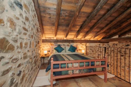 a bedroom with a bed and a stone wall at Mystras Panorama House in Mystras