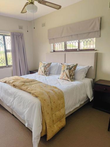 a bedroom with a large bed with white sheets and pillows at Preston House in Park Rynie