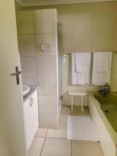 a bathroom with a shower and a tub and a sink at Preston House in Park Rynie