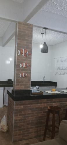 a kitchen with a brick wall with a counter top at Espaço MV Family in Prado