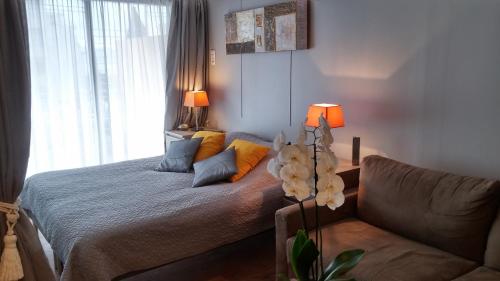 un salon avec un lit et un canapé dans l'établissement SOPHIES HOMES FÉLIBRIGES BEACH & PALAIS des FESTIVALS, à Cannes