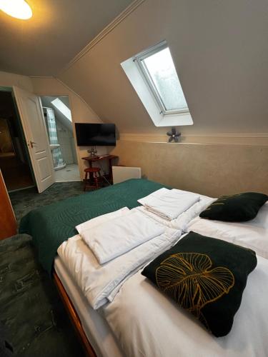 a bedroom with two beds with towels on them at Zöldfa Panzió in Miskolc